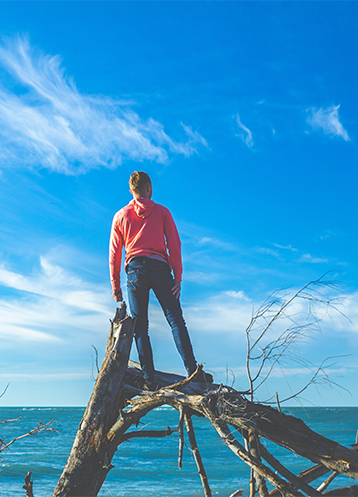man smiling standing on a log